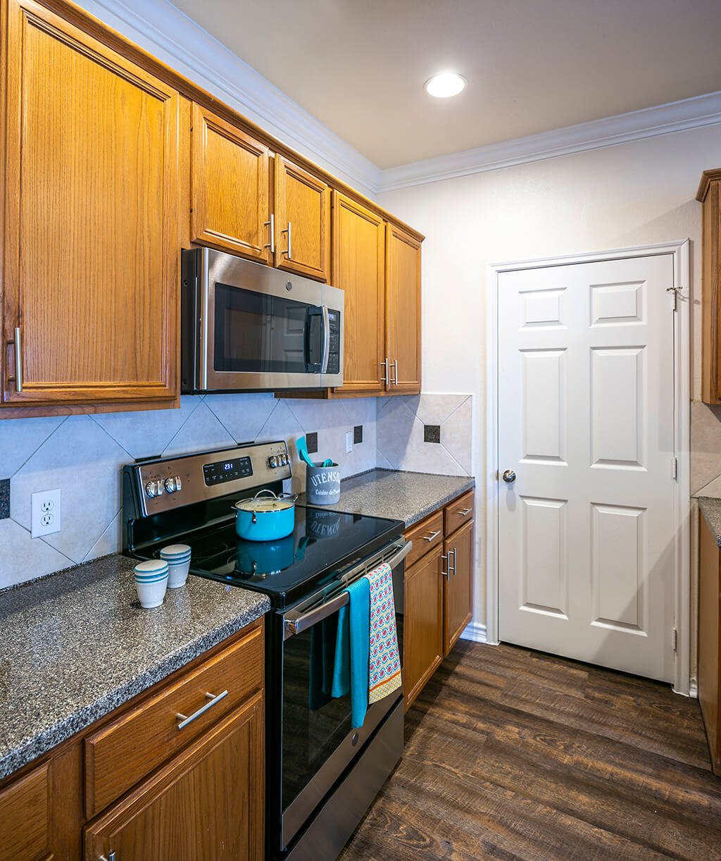A kitchen with a double sink and stainless-steel appliances at The Dominion Apartments in Conroe, Texas.